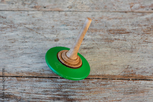 Spinning top against wooden background