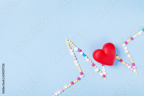 Cardiogram is made of colorful drug pills and red heart. Pharmaceutical and cardiology concept.