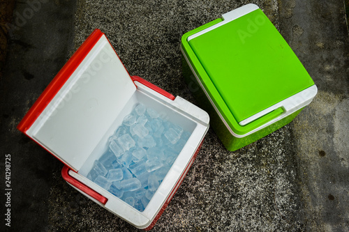 Schilderij op canvas Top view of picnic cooler box with and ice cube on the ground during summer vacation time