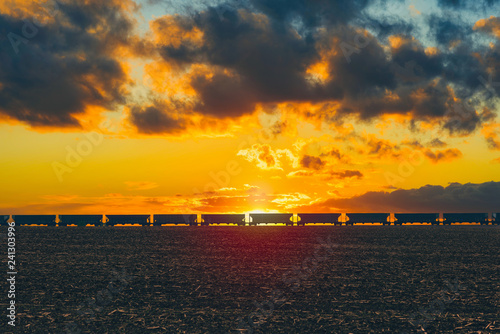фотографія Freight train passing on on the horizon of field  in the American countryside