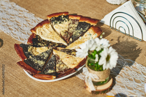 Delicious baked wedding cake and pastry set up on the ructic wooden table photo