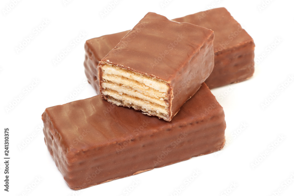 Sweet waffle candies coated with chocolate. One is sliced Sweet waffle candies coated with chocolate. One is sliced