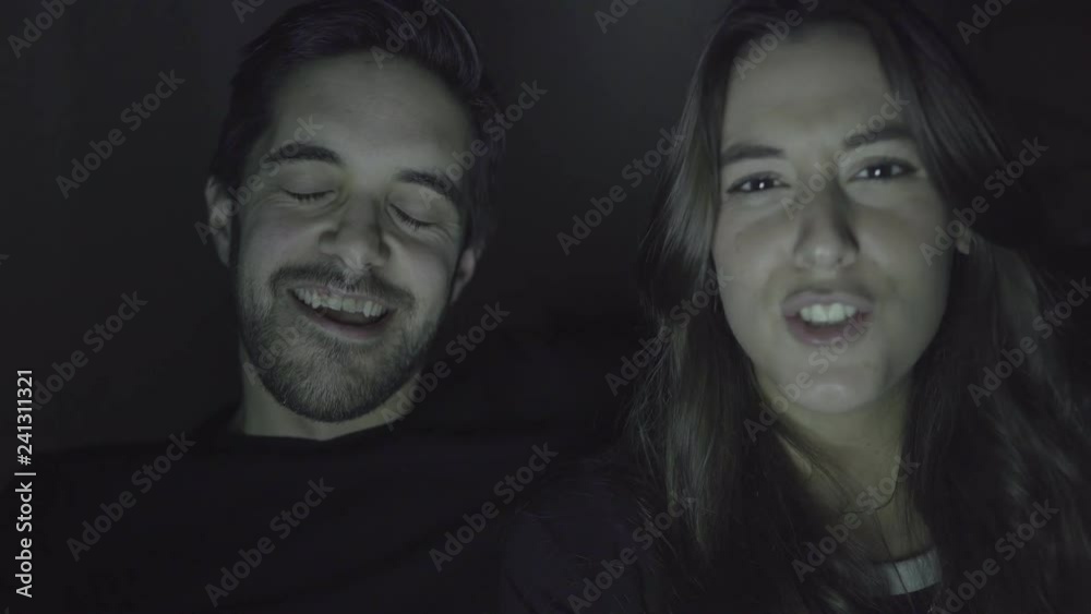 Happy young couple waving hands and talking during video chat. Cheerful young man and woman greeting someone and smiling at camera during pleasant video conversation. Communication concept Happy young couple waving hands and talking during video chat. Cheerful young man and woman greeting someone and smiling at camera during pleasant video conversation. Communication concept