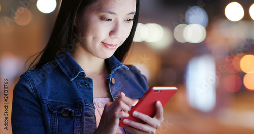 Photography Woman check on cellphone in city at night