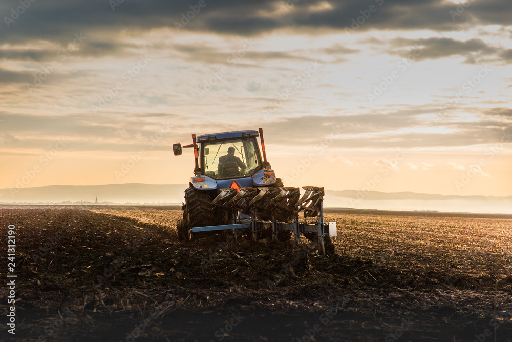 Fototapeta premium Tractor Plowing in dusk