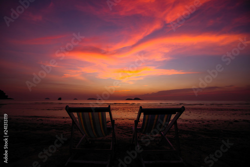 Couple of sun loungers on the beach during twilight. © De Visu