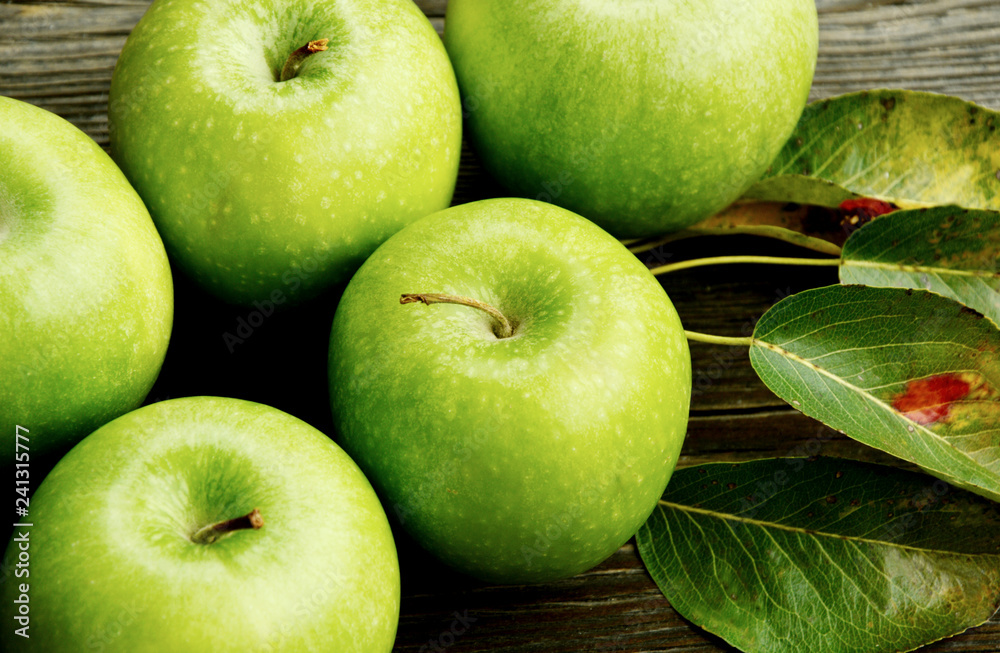 Health Benefits Of Green Apples. Green apples with leaf on wooden background. Health Benefits Of Green Apples. Green apples with leaf on wooden background.