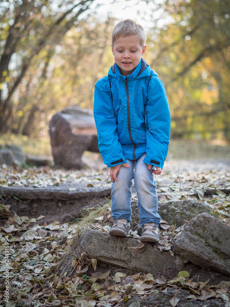 A 7-year-old boy prepared to jump in the autumn park A 7-year-old boy prepared to jump in the autumn park