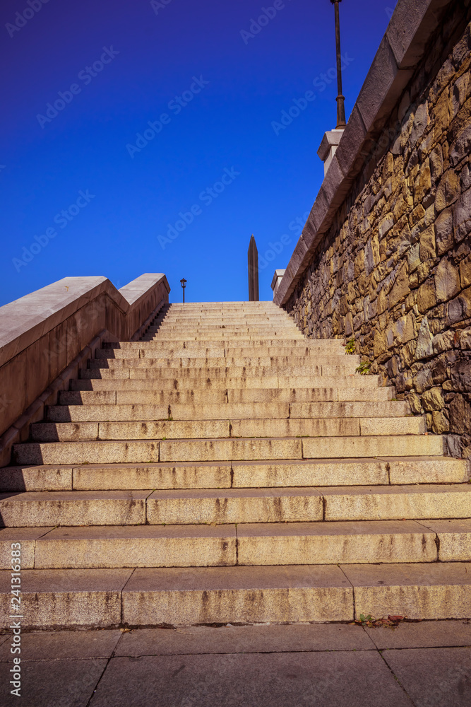 Fototapeta premium Stone stairways at the center of the city during a sunny day.