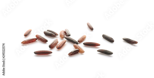 Scattered grains of brown rice on white background