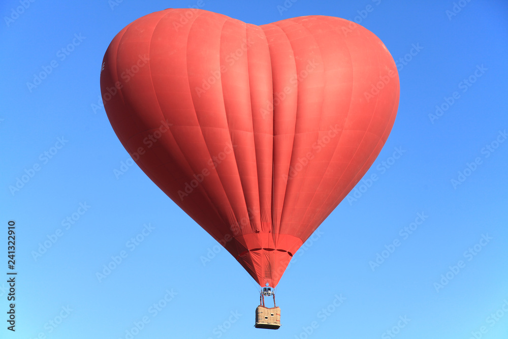 Naklejka Hot air balloon in the shape of the heart is flying in the blue sky. St. Valentine's day