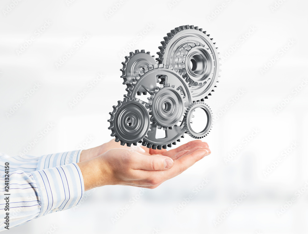 Engine mechanism in male ahnds as symbol for cooperation or teamworking. Mixed media Engine mechanism in male ahnds as symbol for cooperation or teamworking. Mixed media