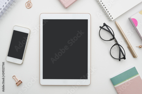 Mockup. Digital tablet with blank screen, smartphone and notepad on table. Woman office workspace. Blog concept.
