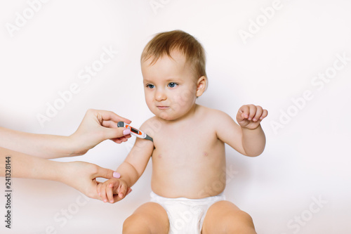 Doctor measures the temperature of little baby. Healthcare and medicine concept at pediatrician department. © sofiko14