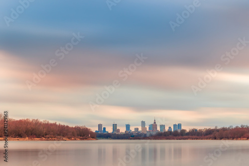 Colorful sunset over the Warsaw downtown. Skyline with the view of contemporary architecture and the Vistula River shorelines.