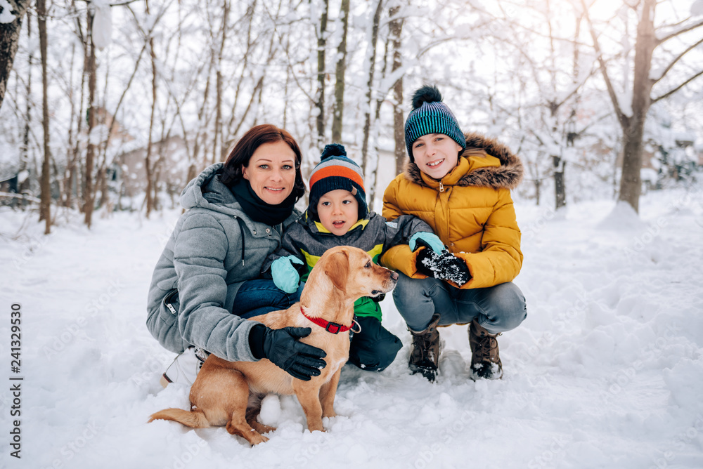 Family with dog playing in the snow