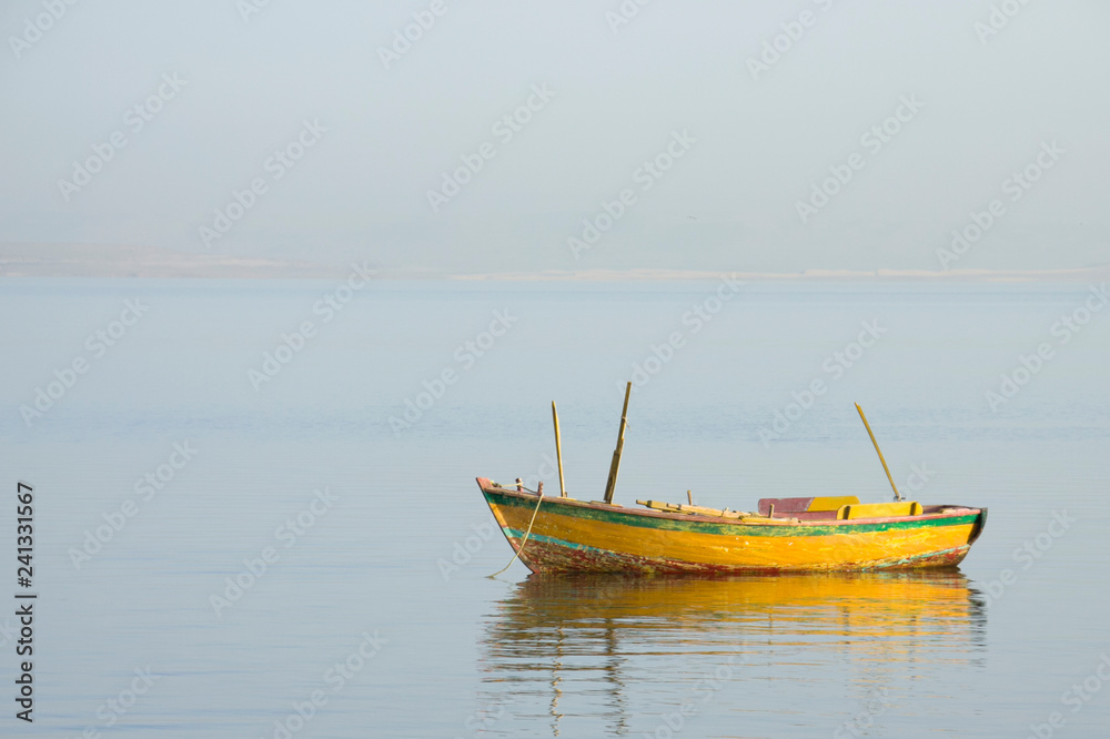 El fayoum - Egypt / June 2011: empty orange boat used by local fishermen living near lake Qaroun in Elfayoum south of Cairo. 