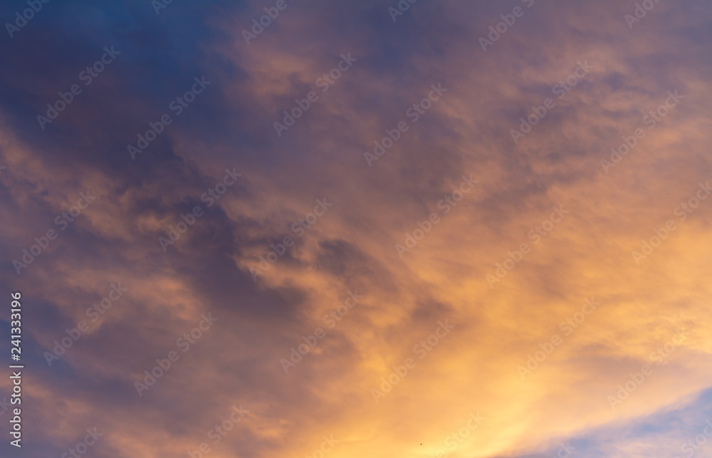 Clouds during sunset. The sky is dyed golden colors.