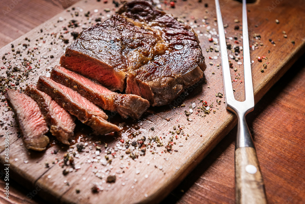 tasty and fresh, very juicy ribbey steak of marbled beef, on a wooden table.
