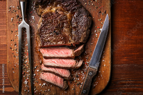 tasty and fresh, very juicy ribbey steak of marbled beef, on a wooden table.