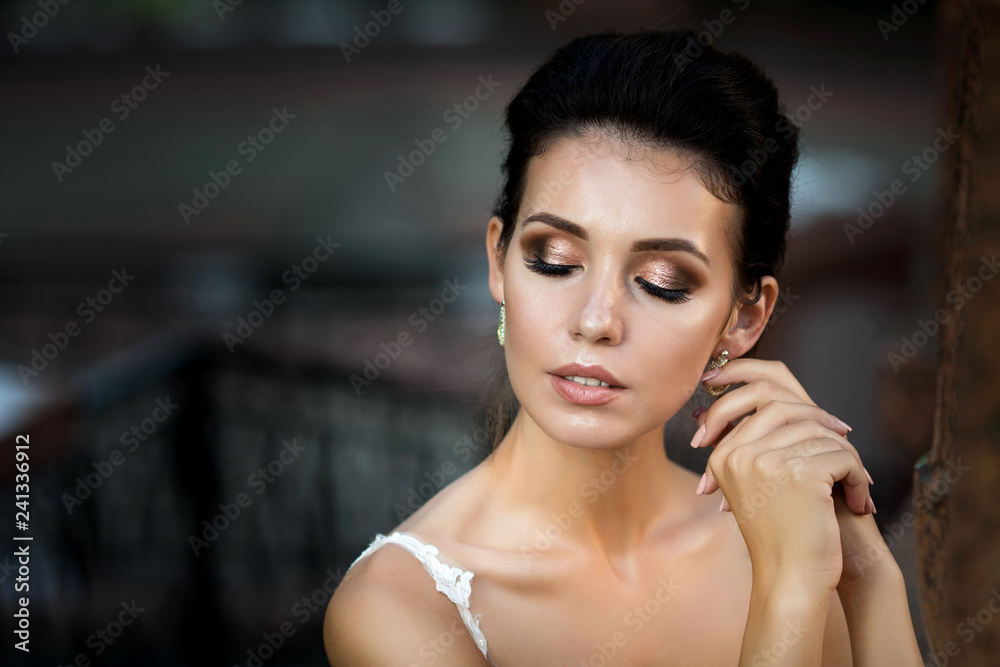 Obraz premium fashion photo of beautiful woman with dark hair in luxurious wedding dress posing outdoor.