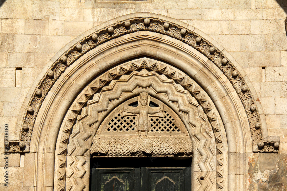 arco del portale meridionale della Cattedrale di Bitonto con immagine di Cristo in croce in abiti regali