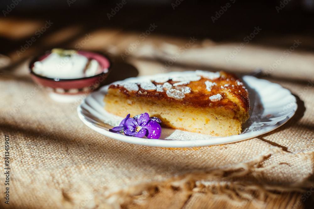piece of orange and almond cake with cream on the table