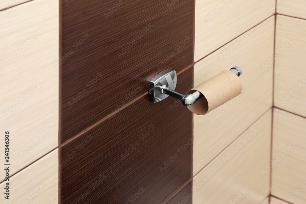 Holder with empty toilet paper roll in bathroom Holder with empty toilet paper roll in bathroom