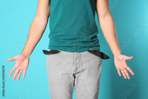 Man showing empty pockets on color background, closeup © New Africa