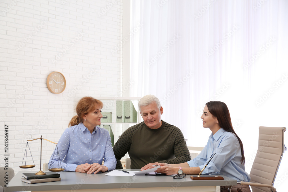 Fototapeta premium Young lawyer consulting senior couple in office