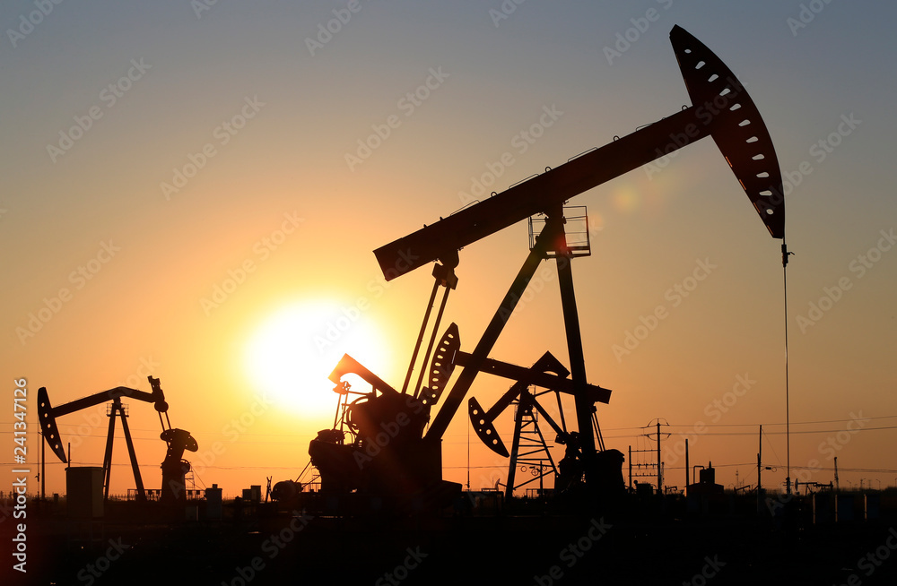 The pumping unit is working in the setting sun The pumping unit is working in the setting sun