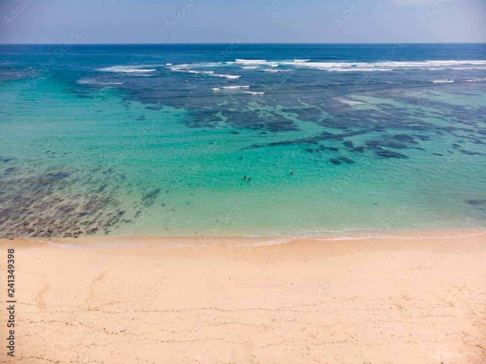 Obraz premium Vertical view of Pandawa Beach , Bali with some people in the water for scale