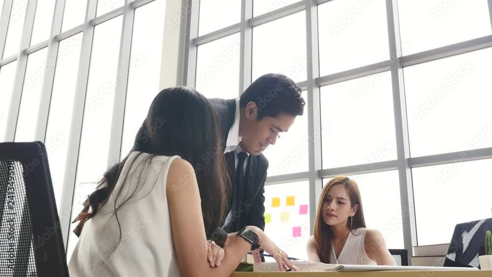Asian Businesspeople are brainstorming while meeting together at the office. Asian Businesspeople are brainstorming while meeting together at the office.