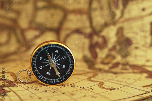 Compass on blur vintage map background, retro color tone, direction journey planning concept, blank space, top view © sundaemorning