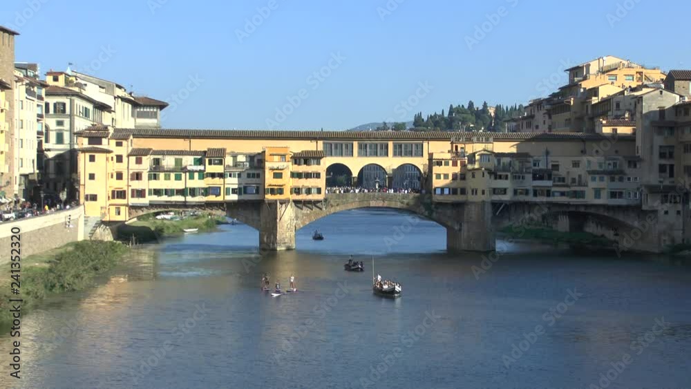 Florence, Italy. View of the Arno River with boats and Ponte Vecchio. Florence, Italy. View of the Arno River with boats and Ponte Vecchio.