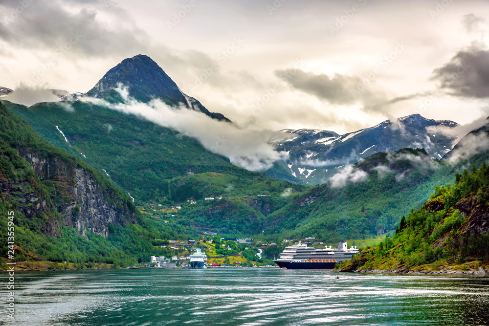 Huge cruiser in the middle of the fjords with high peak mountain in Norway