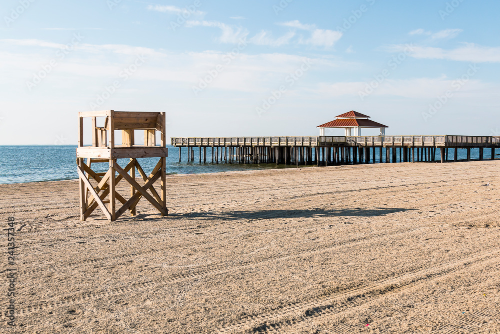 Lifeguard tower on an empty beach with the public viewing pier at Buckroe Beach in Hampton, Virginia. Lifeguard tower on an empty beach with the public viewing pier at Buckroe Beach in Hampton, Virginia.