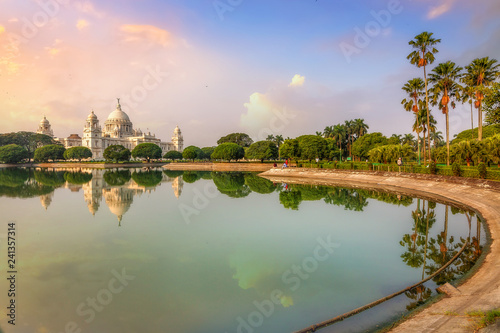 Scenic Victoria Memorial Kolkata at sunrise with water reflection.