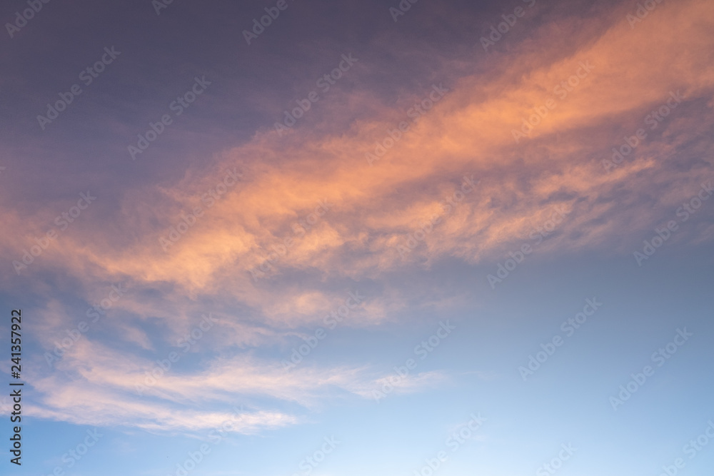 Sunset or sunrise sky with clouds and sunlight.
