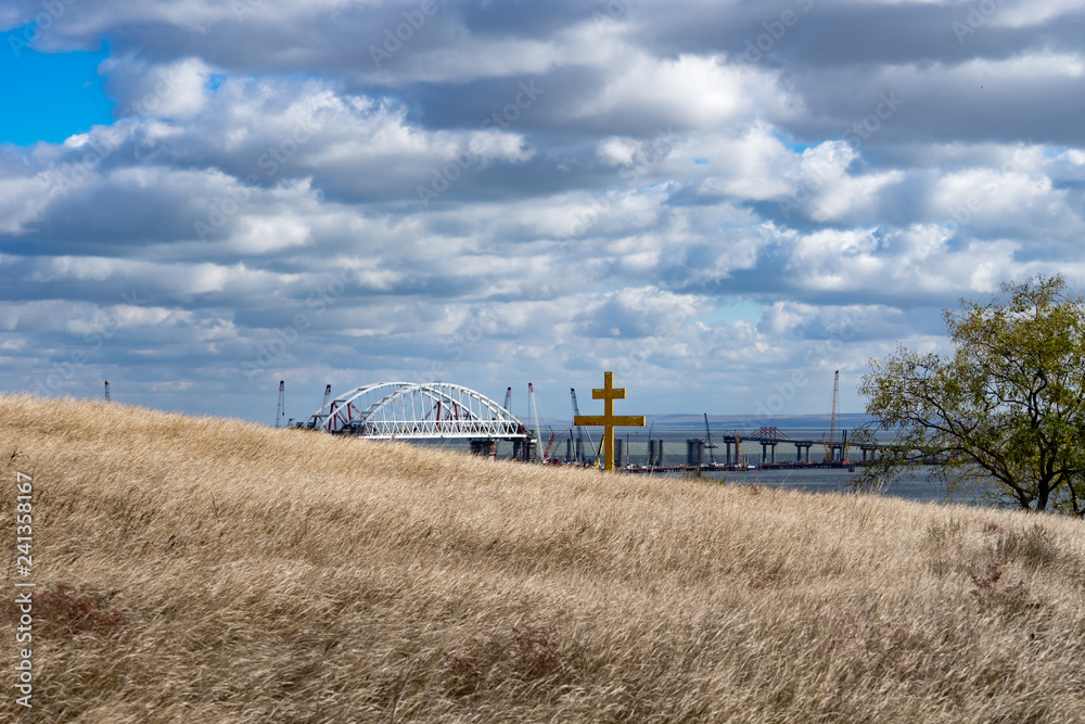 Fototapeta premium The gilded cross blesses the Crimean bridge.