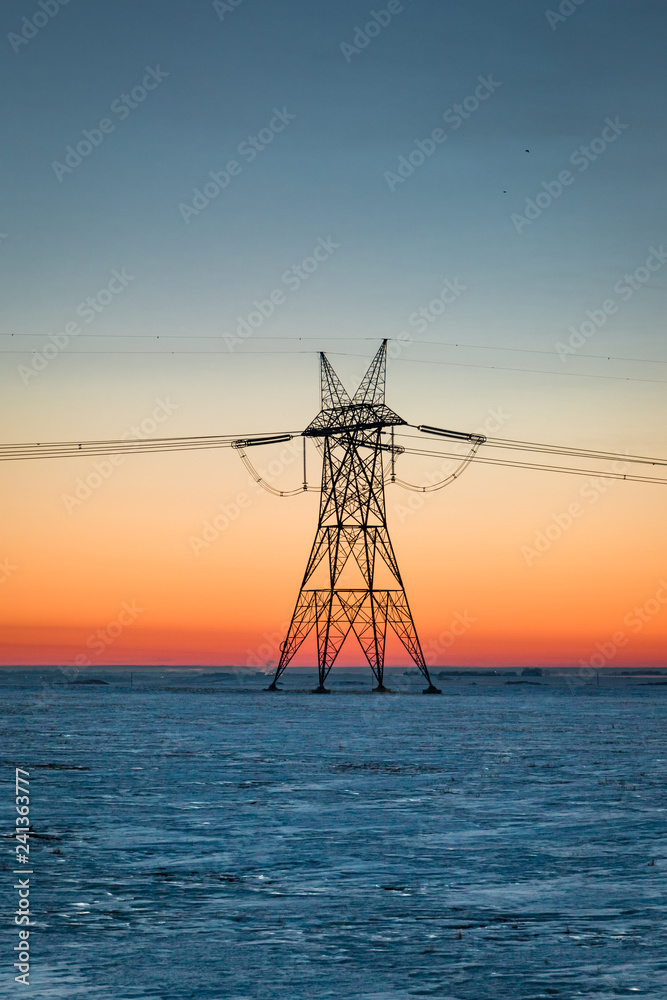 Electrical tower on a prairie winter dawn in January