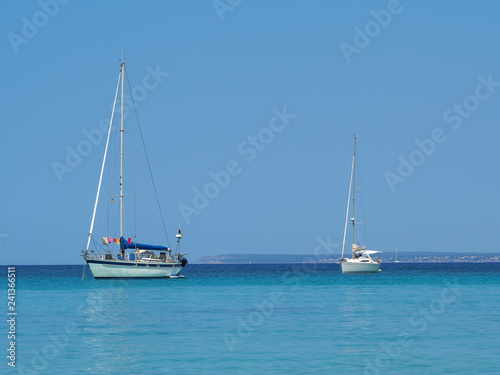 Colonia Sant Jordi, Ses Salines, Spain. Amazing view of the boats with a turquoise sea close to the charming beach of Es Trencs. It has earned the reputation of Caribbean beach of Mallorca