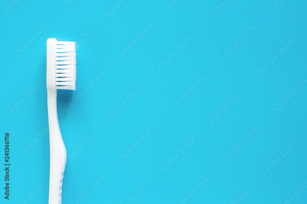 White toothbrush used for cleaning the teeth on blue background for dental care concept White toothbrush used for cleaning the teeth on blue background for dental care concept