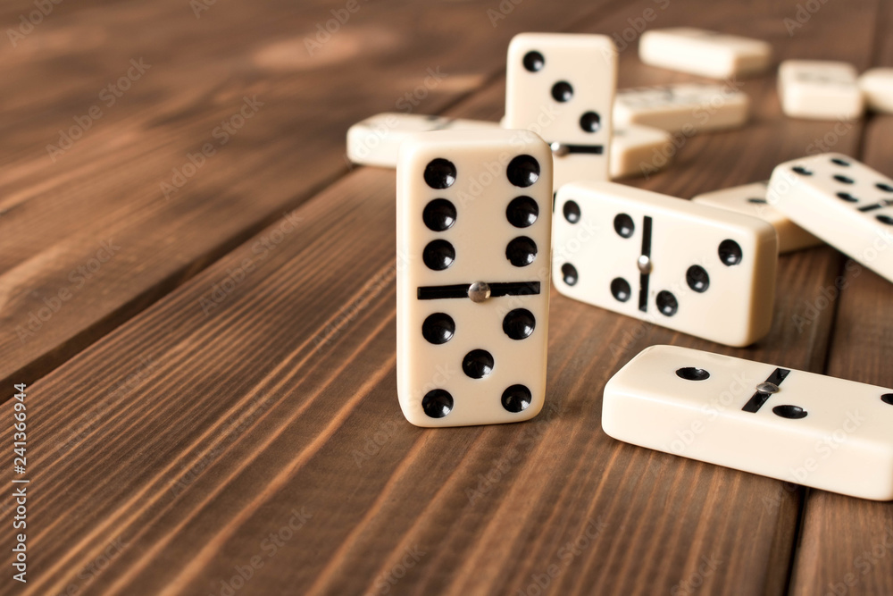 Playing dominoes on a wooden table. Domino effect