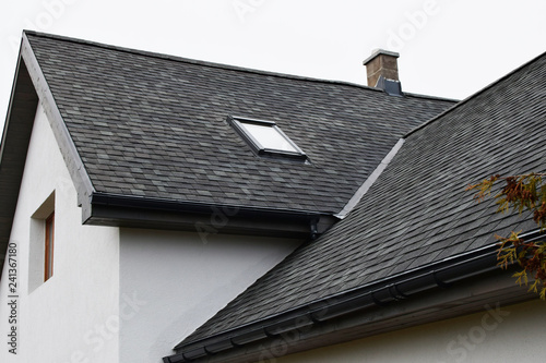 Wallpaper Mural Part of white house with new wooden eaves, plastic rain gutter, window and chimney in grey shingles roof and brown window in facade  with copy space on sky. Torontodigital.ca