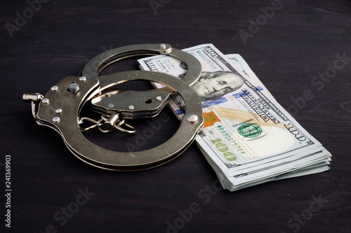 Handcuffs and money. Dollars for bail bonds.