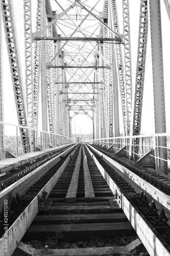 monochrome photo of the bridge on the railroad tracks and industrial gray stone