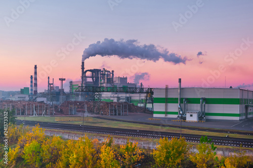 pipes of woodworking enterprise plant sawmill in the morning dawn. Air pollution concept. Industrial landscape environmental pollution waste of thermal power plant