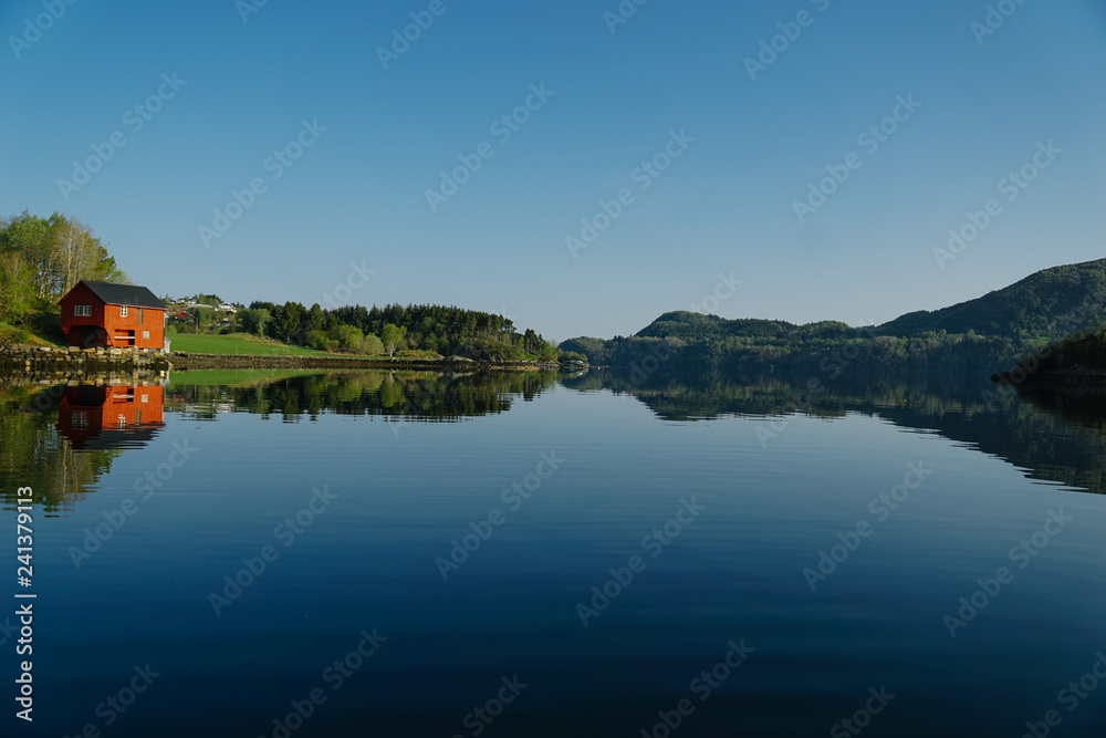 Norway beautiful spring landscape. Mountains reflection in calm water of fjord