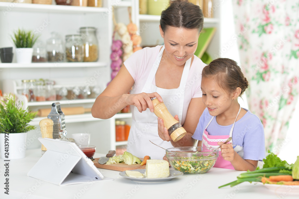Portrait of smiling mother and daughter cooking together Portrait of smiling mother and daughter cooking together